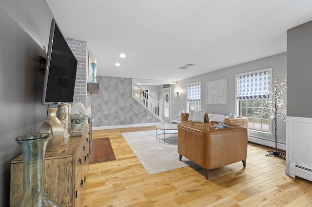 2 Ridgewood Dr, Kingston, NH 03848 - living area with stairway, baseboard heating, wood finished floors, an accent wall, and wainscoting