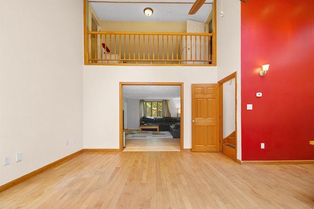 17 N Ave, Plaistow, NH 03865 - unfurnished living room with wood finished floors, a towering ceiling, stairway, and a ceiling fan