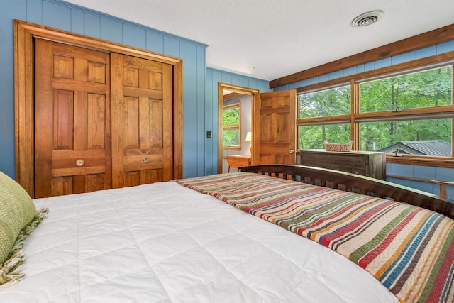 679 Kearsarge Rd, Conway, NH 03860 - bedroom featuring a textured ceiling, a closet, and wood walls