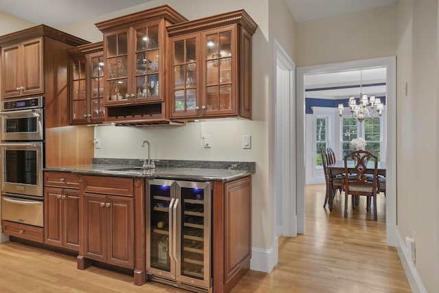4 Chablis Ct, Bedford, NH 03110 - indoor wet bar with wine cooler, a warming drawer, a chandelier, and light wood-style floors