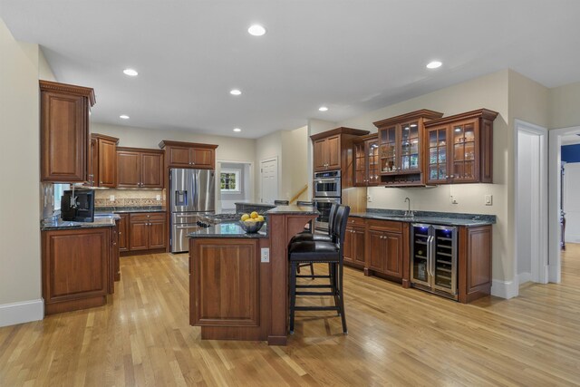4 Chablis Ct, Bedford, NH 03110 - kitchen with beverage cooler, appliances with stainless steel finishes, light wood-style flooring, a breakfast bar, and a center island