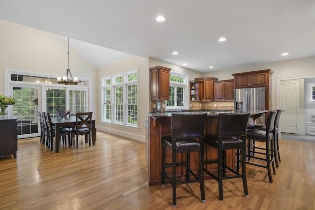 4 Chablis Ct, Bedford, NH 03110 - kitchen with dark countertops, a breakfast bar area, open shelves, a chandelier, and light wood-style floors