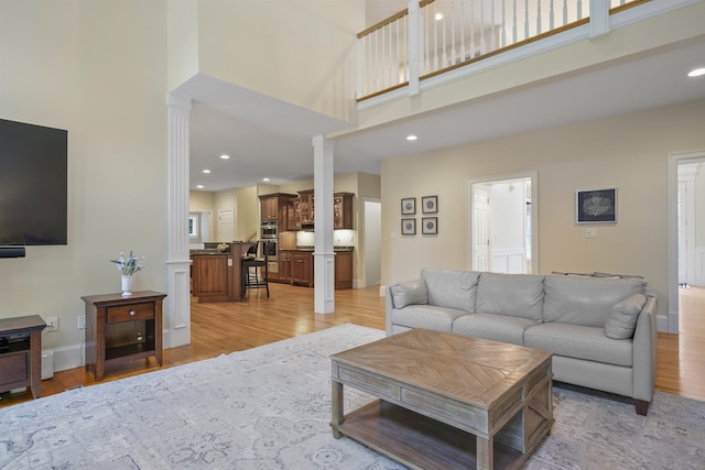 4 Chablis Ct, Bedford, NH 03110 - living room featuring light wood-style floors, a towering ceiling, recessed lighting, and decorative columns