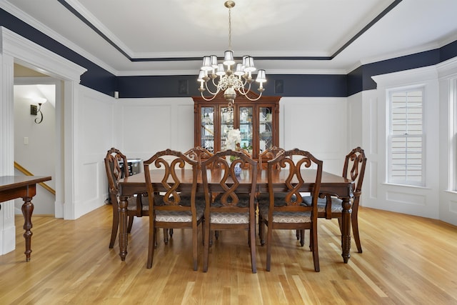 4 Chablis Ct, Bedford, NH 03110 - dining area with a decorative wall, a chandelier, light wood-style flooring, a raised ceiling, and a wainscoted wall