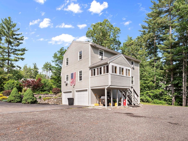 44 Mcquade Brook Rd, Bedford, NH 03110 - view of front of property with a sunroom, stairs, a garage, and driveway
