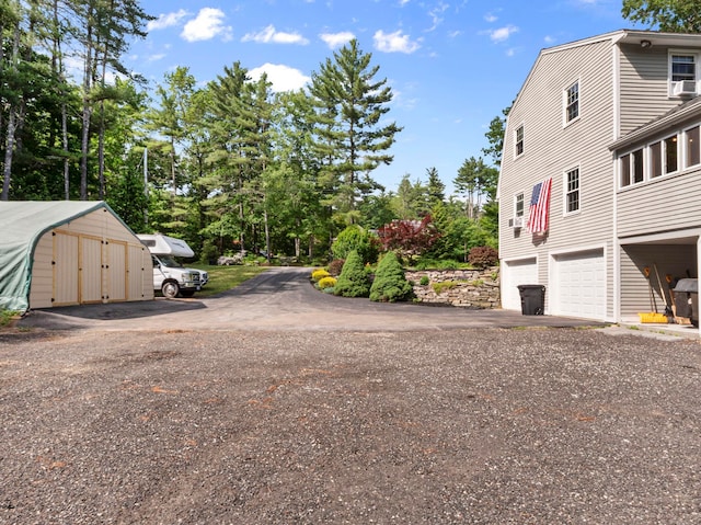 44 Mcquade Brook Rd, Bedford, NH 03110 - view of side of property with a garage and asphalt driveway