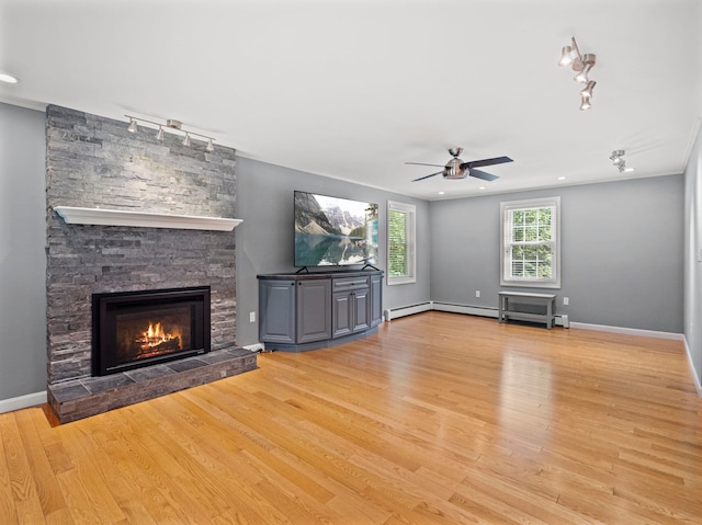 44 Mcquade Brook Rd, Bedford, NH 03110 - unfurnished living room featuring rail lighting, a ceiling fan, a stone fireplace, wood finished floors, and recessed lighting
