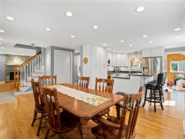 44 Mcquade Brook Rd, Bedford, NH 03110 - dining room with stairs, light wood finished floors, recessed lighting, and a fireplace