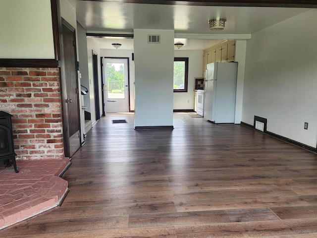 33 Pendleton Ln, Londonderry, NH 03053 - unfurnished living room featuring a wood stove and dark wood-style floors