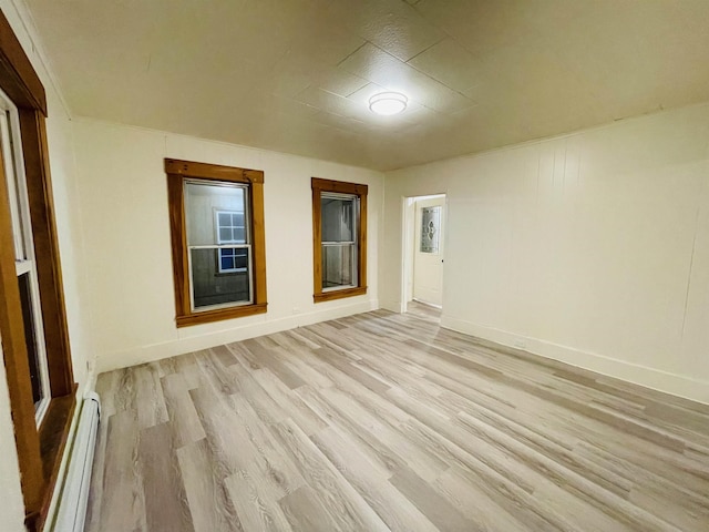 17 Arch St, Laconia, NH 03246 - empty room with a baseboard radiator and light wood finished floors