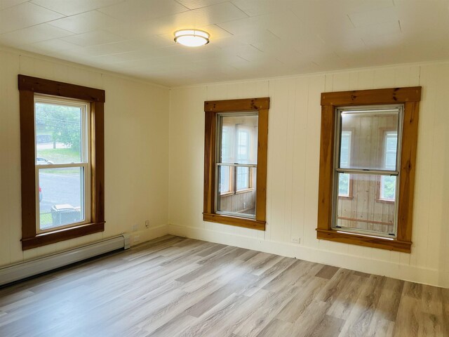 17 Arch St, Laconia, NH 03246 - empty room featuring a baseboard heating unit and light wood-style flooring