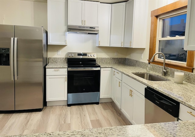 17 Arch St, Laconia, NH 03246 - kitchen with stainless steel appliances, under cabinet range hood, white cabinetry, and light stone countertops