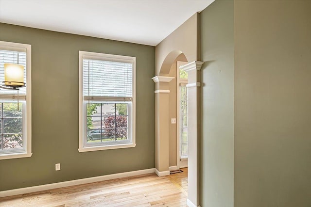 473 Brennan Woods Dr, Williston, VT 05495 - unfurnished room with light wood-type flooring, plenty of natural light, ornate columns, and arched walkways