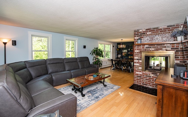 33 Hillside Rd, Kingston, NH 03848 - living area featuring hardwood / wood-style floors, a chandelier, baseboard heating, and a textured ceiling