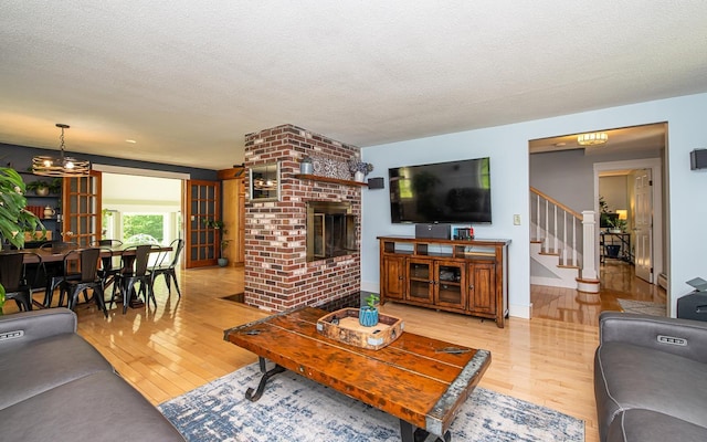 33 Hillside Rd, Kingston, NH 03848 - living area with hardwood / wood-style flooring, stairs, a textured ceiling, and a fireplace