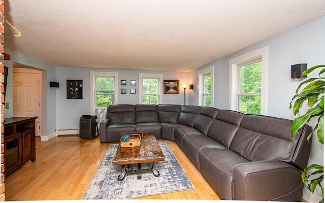 33 Hillside Rd, Kingston, NH 03848 - living area featuring light wood finished floors, a baseboard heating unit, and a textured ceiling