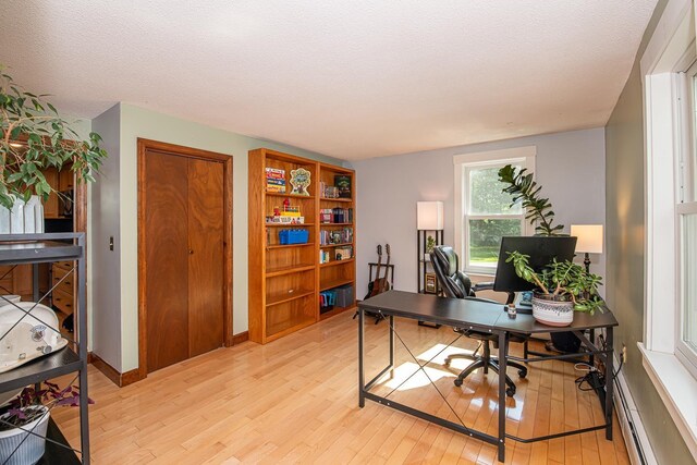 33 Hillside Rd, Kingston, NH 03848 - office area featuring light wood-style flooring, a baseboard radiator, and a textured ceiling