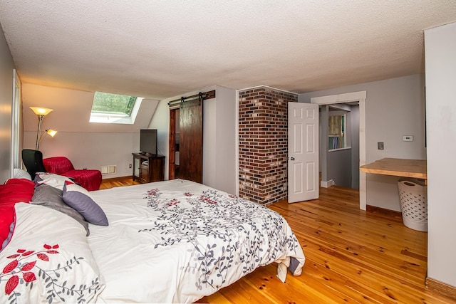 33 Hillside Rd, Kingston, NH 03848 - bedroom with hardwood / wood-style flooring, a skylight, and a textured ceiling
