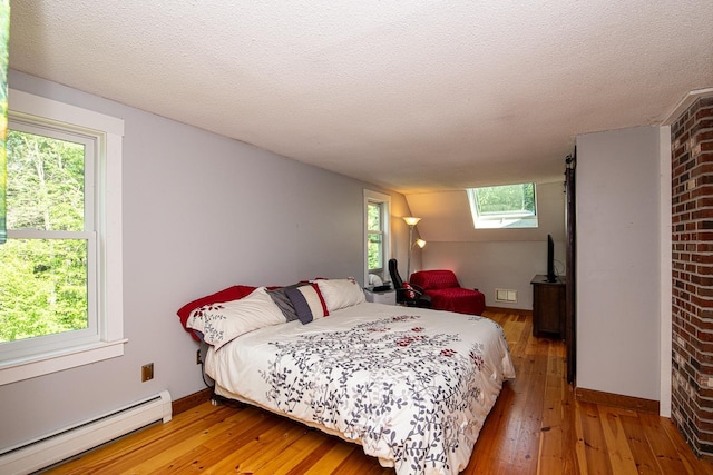 33 Hillside Rd, Kingston, NH 03848 - bedroom featuring a baseboard heating unit, light wood-style floors, a textured ceiling, and a skylight