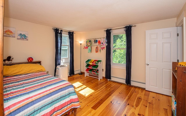 33 Hillside Rd, Kingston, NH 03848 - bedroom with light wood-style floors, a baseboard radiator, and a baseboard heating unit