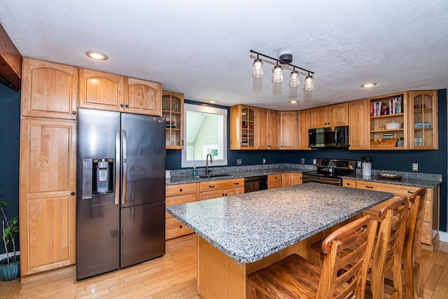 33 Hillside Rd, Kingston, NH 03848 - kitchen with appliances with stainless steel finishes, light wood-type flooring, a textured ceiling, a breakfast bar, and dark stone counters