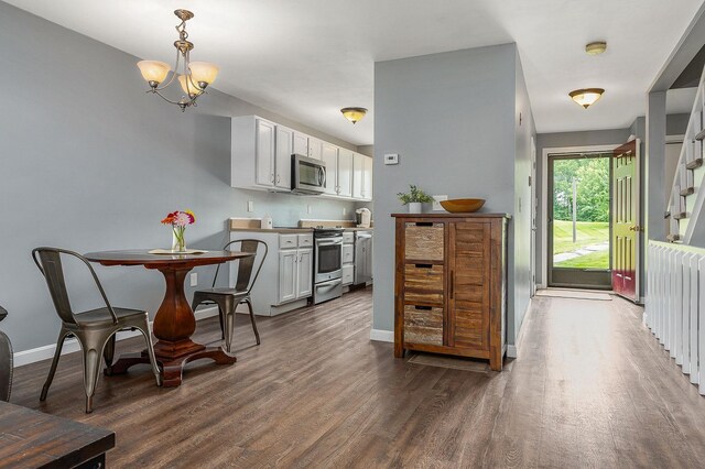 37 Thornhill Rd, Stratham, NH 03885 - kitchen featuring stainless steel appliances, dark wood-style flooring, a chandelier, decorative light fixtures, and white cabinetry
