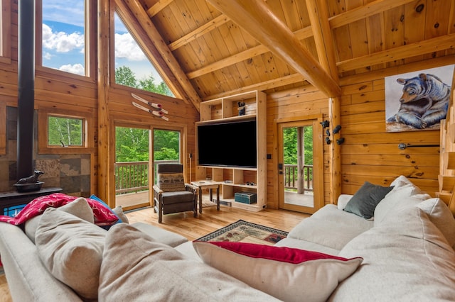 1 Peak Vista Ln, Madison, NH 03849 - living room featuring a wood stove, wooden walls, plenty of natural light, wood finished floors, and a wood ceiling with exposed beams