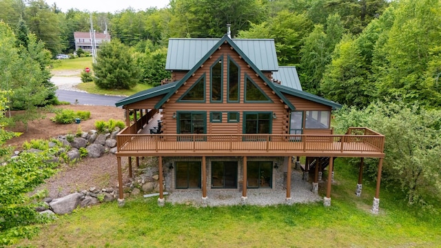 1 Peak Vista Ln, Madison, NH 03849 - rear view of house with log exterior, a deck, a standing seam roof, and a wooded view