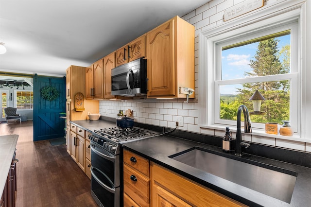 174 E Colebrook Rd, Colebrook, NH 03576 - kitchen featuring appliances with stainless steel finishes, dark countertops, dark wood finished floors, decorative backsplash, and brown cabinetry