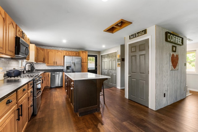 174 E Colebrook Rd, Colebrook, NH 03576 - kitchen featuring stainless steel appliances, dark wood-style flooring, backsplash, a center island, and a kitchen bar
