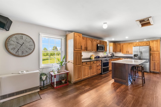 174 E Colebrook Rd, Colebrook, NH 03576 - kitchen featuring appliances with stainless steel finishes, dark wood-style flooring, a kitchen bar, backsplash, and recessed lighting