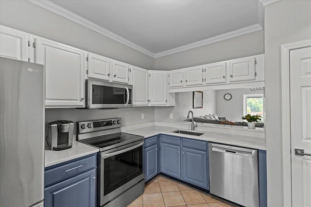 8 Kristen Ct, Williston, VT 05495 - kitchen with stainless steel appliances, blue cabinetry, light tile patterned flooring, white cabinets, and ornamental molding