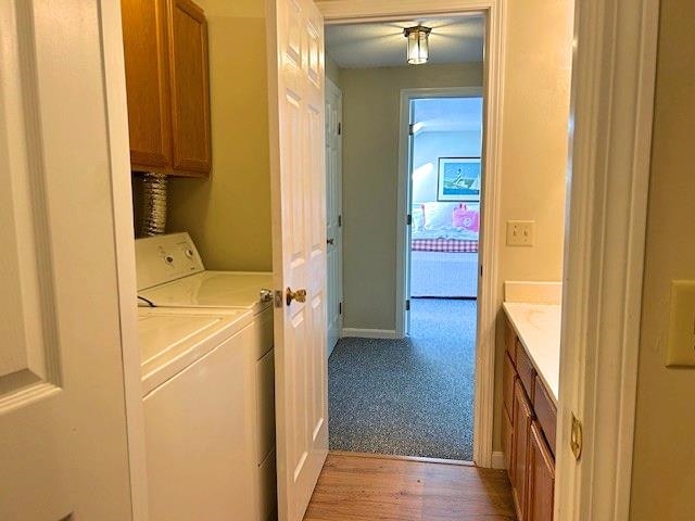 38C Stonehouse Ln, Keene, NH 03431 - laundry area featuring cabinet space, washer and clothes dryer, and light wood-style floors