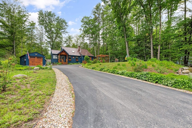 85 Lakeview Ave, Bristol, NH 03222 - view of front facade featuring a chimney, a standing seam roof, asphalt driveway, a metal roof, and an outdoor structure