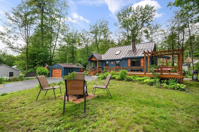 85 Lakeview Ave, Bristol, NH 03222 - view of green lawn featuring an outdoor structure, a garage, a deck, a pergola, and driveway