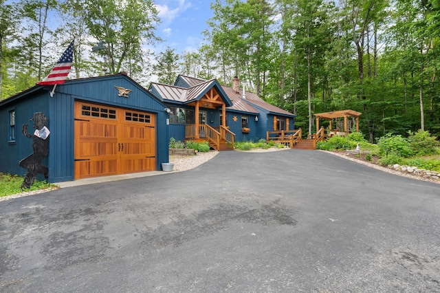 85 Lakeview Ave, Bristol, NH 03222 - view of front of property featuring a chimney, a metal roof, a garage, driveway, and a standing seam roof