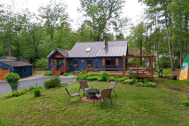 85 Lakeview Ave, Bristol, NH 03222 - rear view of property with a fire pit, a chimney, a metal roof, a lawn, and a standing seam roof