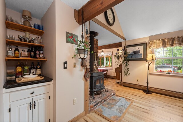 85 Lakeview Ave, Bristol, NH 03222 - indoor dry bar featuring a wood stove, light wood finished floors, and vaulted ceiling
