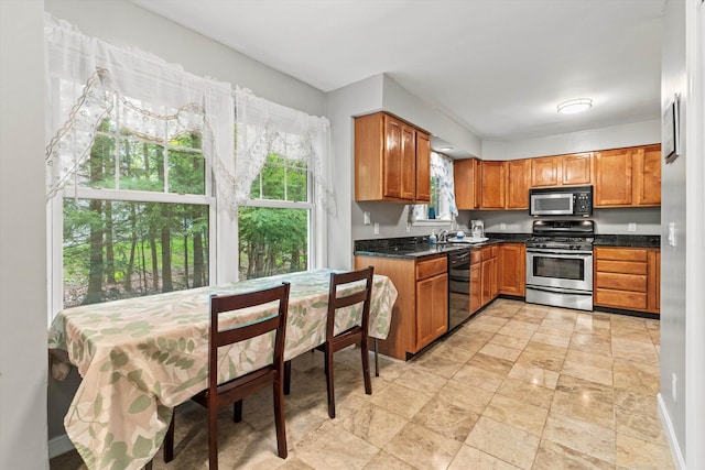 25 Sweetbrier Way, Laconia, NH 03246 - kitchen with stainless steel gas stove, black dishwasher, dark countertops, and brown cabinetry