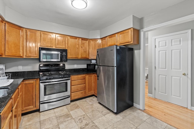 25 Sweetbrier Way, Laconia, NH 03246 - kitchen with stainless steel appliances, dark stone counters, and brown cabinets