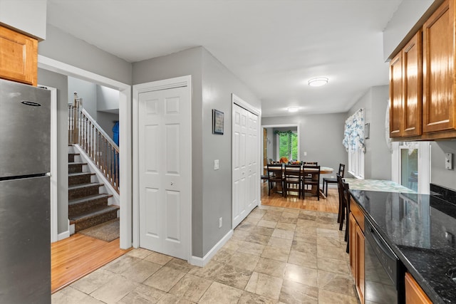 25 Sweetbrier Way, Laconia, NH 03246 - kitchen with freestanding refrigerator, dark stone counters, and brown cabinets