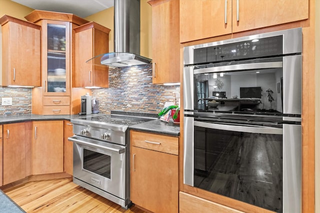 10 Benjamins Way, Hollis, NH 03049 - kitchen featuring stainless steel appliances, wall chimney exhaust hood, light wood finished floors, tasteful backsplash, and dark countertops