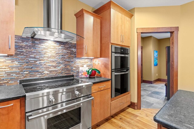 10 Benjamins Way, Hollis, NH 03049 - kitchen with appliances with stainless steel finishes, exhaust hood, dark countertops, decorative backsplash, and light wood-type flooring