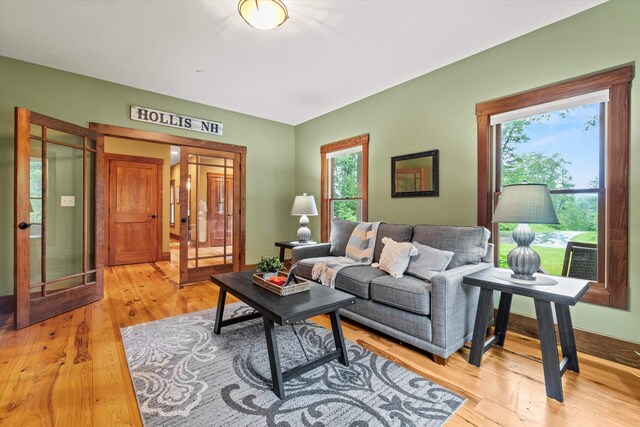 10 Benjamins Way, Hollis, NH 03049 - living area featuring healthy amount of natural light, french doors, and light wood finished floors
