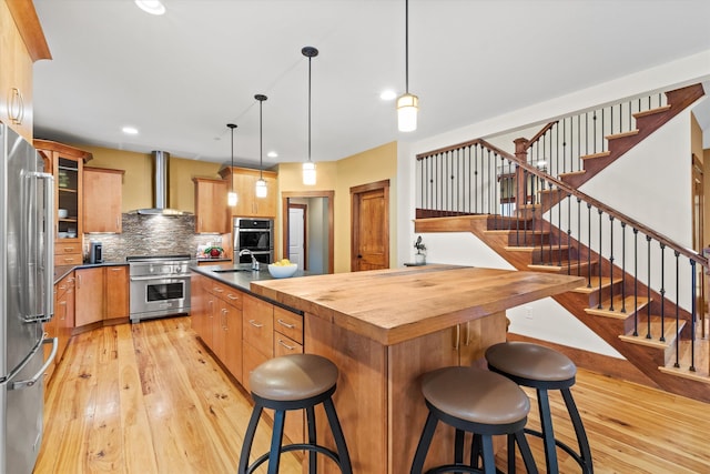 10 Benjamins Way, Hollis, NH 03049 - kitchen with stainless steel appliances, wall chimney range hood, light wood-style floors, an island with sink, and recessed lighting