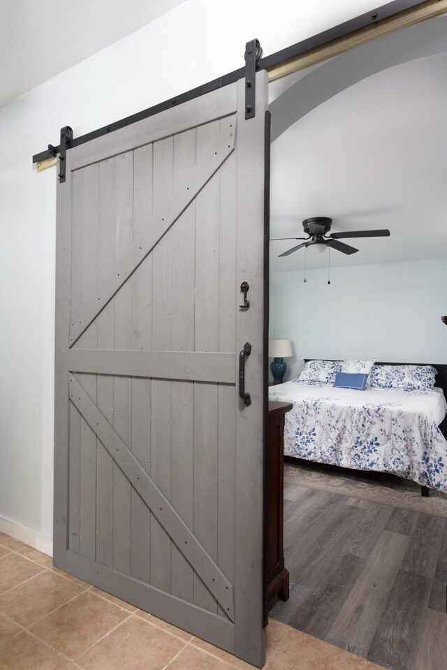24 Church St, Wakefield, NH 03872 - bedroom with a barn door, a ceiling fan, and tile patterned flooring