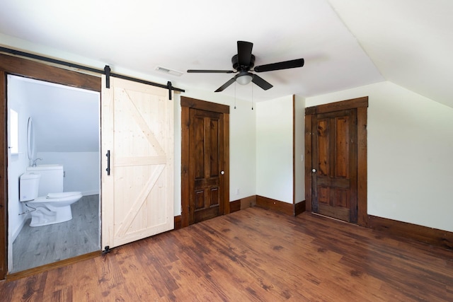 24 Church St, Wakefield, NH 03872 - unfurnished bedroom with a barn door, wood finished floors, vaulted ceiling, ensuite bathroom, and a ceiling fan