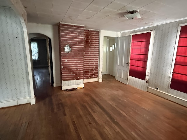 60 S St S, Proctor, VT 05763 - unfurnished room featuring arched walkways, wallpapered walls, and wood finished floors