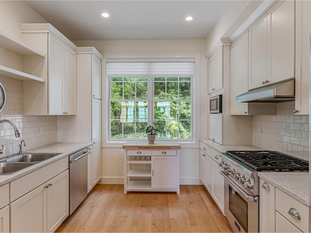 200 Lake St Unit 10, Burlington, VT 05401 - kitchen featuring stainless steel appliances, under cabinet range hood, open shelves, light countertops, and light wood finished floors