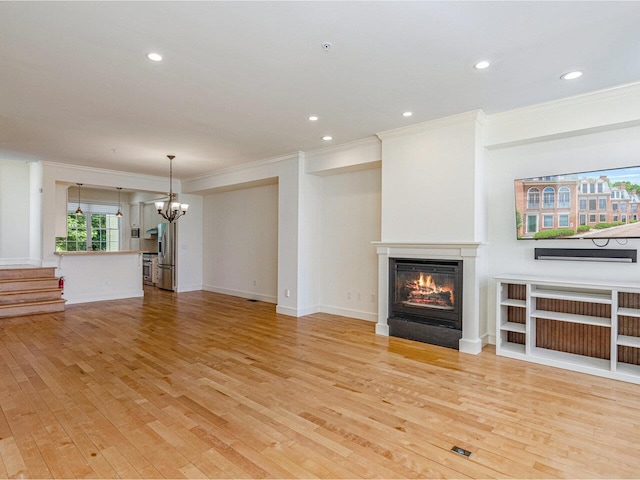 200 Lake St Unit 10, Burlington, VT 05401 - unfurnished living room with crown molding, a chandelier, a glass covered fireplace, light wood finished floors, and recessed lighting